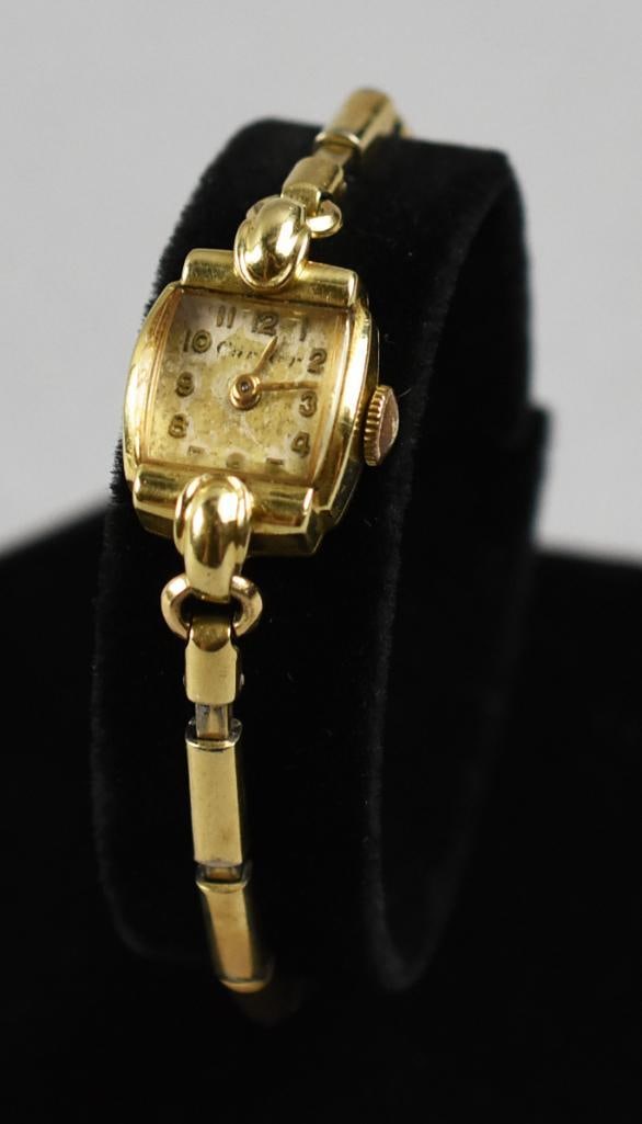Mid Century c1950 Cartier 14K Yellow Gold Ladies Watch: This beautiful watch is from Cartier. It appears to be from the 1950s with rounded corner square case in a mid century Art Deco style. It is attached to a coordinating stretch band that is 10K gold fi