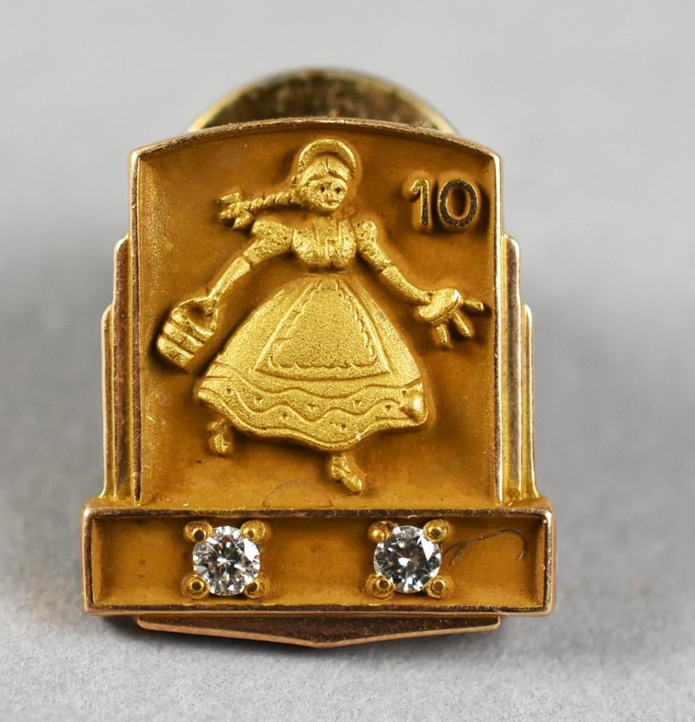 10k Dolly Madison Farmer's Daughter Dia. Lapel Pin: Dainty Dolly Madison. A vintage Dolly Madison 10-year employee service pin in 10k yellow gold and set?with 2 small natural diamonds. Could also be the Farmer's Daughter carrying her milking stool and