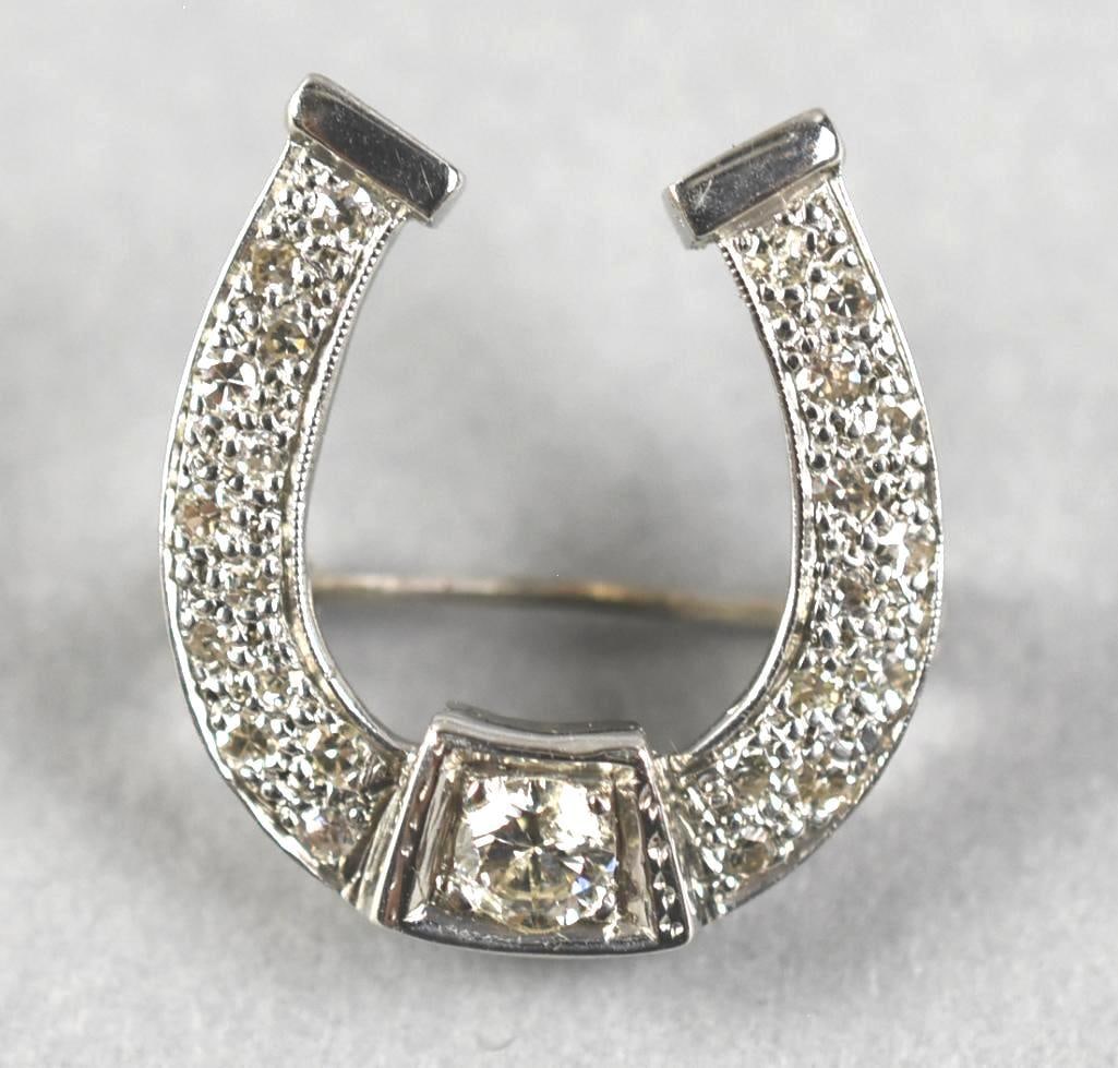 Vintage 18K White Gold & Diamond Encrusted Horseshoe Brooch: This remarkable piece is a vintage brooch in the form of a lucky horseshoe. It is crafted in 18K white gold with round cut diamonds, the center diamond is much larger. There is no visible marks, tests