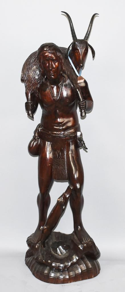 Huge Hand Carved Wooden Native Hunter w/ Goat, 41" Tall: This is a wonderful Native American hunter in his garb. He is hand carved in wood with rich finish. He has a goat around his shoulder. Small animal near the leg missing piece of one ear and has mark o