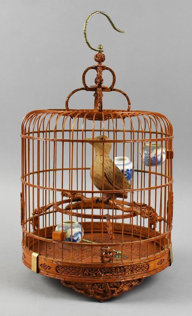 Antique Chinese Split Bamboo Birdcage: Wonderful antique birdcage from China. It appears to be hand crafted from split bamboo. Hook appears brass with bamboo detail, ornate carved loops attach to top of cage,? bird inside appears teak and 