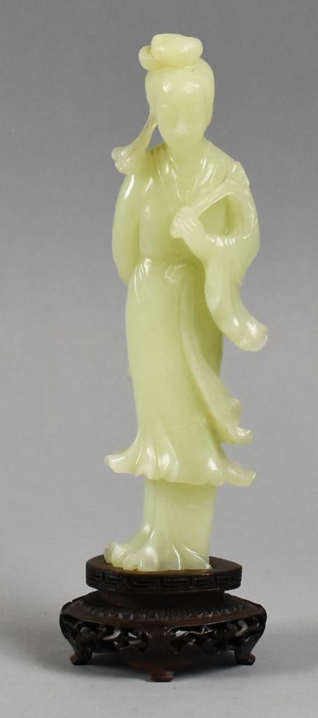 Vintage Chinese Hand Carved Jade Guanyin Figure: Wonderful vintage carved figure from China. She appears hand carved in jade in the form of a Guanyin. She comes with her own stand that is attached. Stands approx. 8" tall. From the estate of a collec