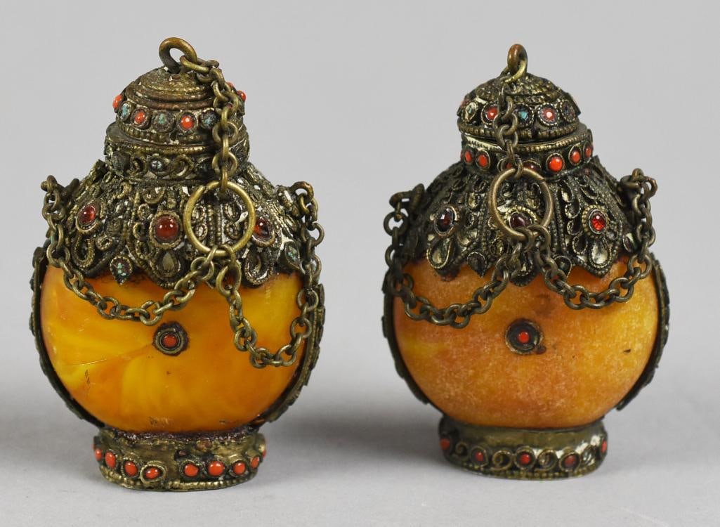 Antique Chinese Amber Snuff Bottle Pair, Stone Inlay: Wonderful pair of antique snuff bottles from China. Stone appears to be amber with what appears to be brass shoulder, cap and base with inlay of coral, turquoise and possibly carnelian. Lids with spoo