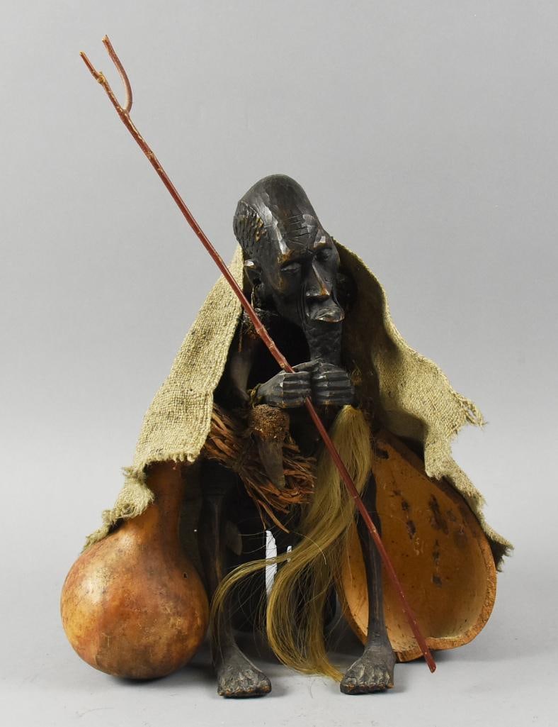 Vintage African Makonde Elder Carved Ebony Sculpture: Amazing vintage or antique sculpture appears to be ebony wood. Hand carving of a Makonde (east African) elder draped in burlap, holds a stick and sits next to a gourd. Pieces held together by natural 