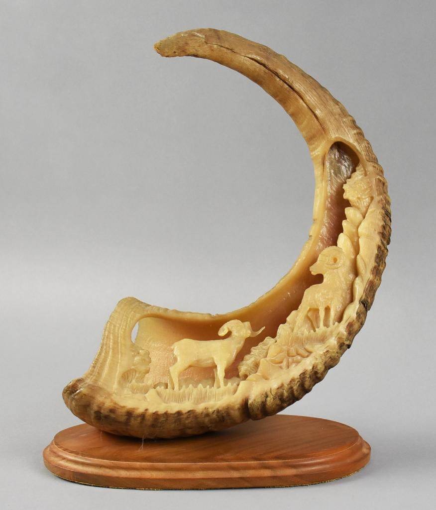 Don Connors Carved Ram Antler, Ram Design: Awesome antler art from folk artist Don Connors. Appears to be a ram antler with rams climbing a mountainside. It is mounted to an oval base. Signed on back and measures approx. 14" x 10".?From the