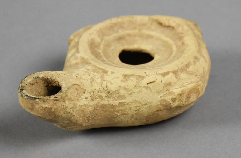 Ancient 100-300 AD Roman Terra Cotta Oil Lamp: This is an amazing ancient Roman oil lamp. Appears to be terracotta with center hole and wick spout and subtle handles. Measures approx. 1" x 2.5" x 4". From the estate of a collector of excellent