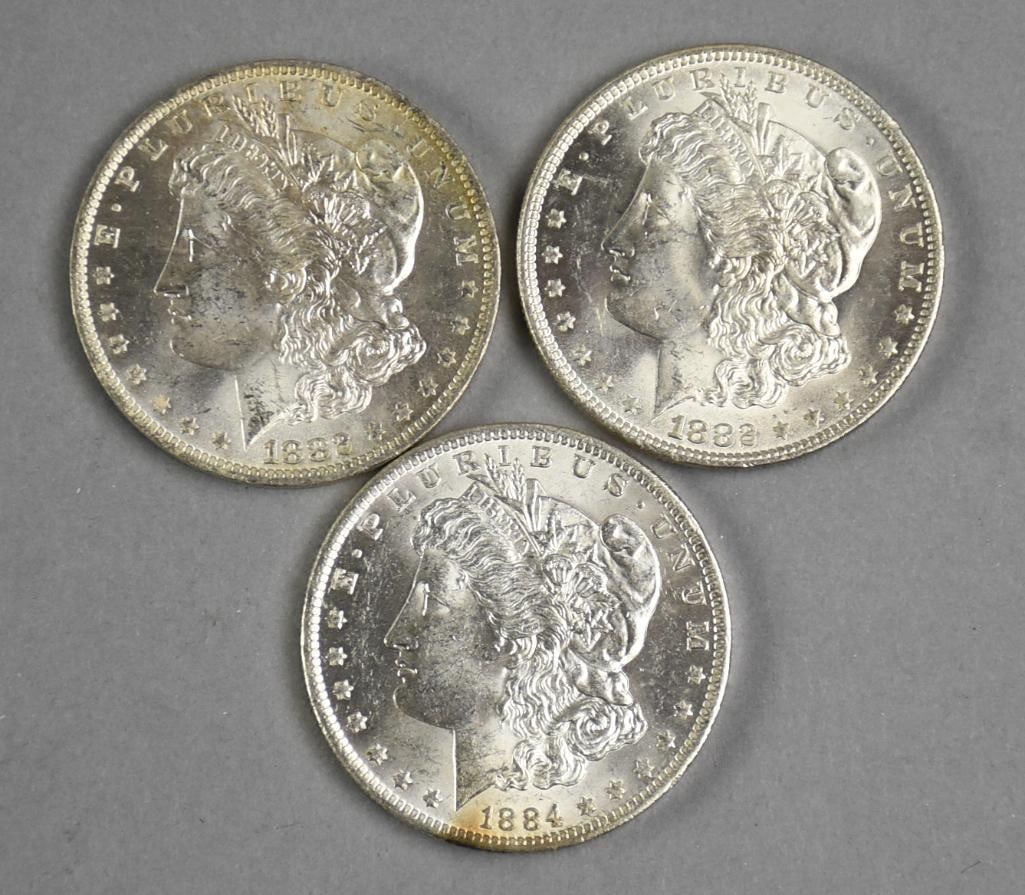 1882, 1884 Morgan Silver Dollars - EX: These are three extremely fine Morgan silver dollars, one 1884 and two 1882.