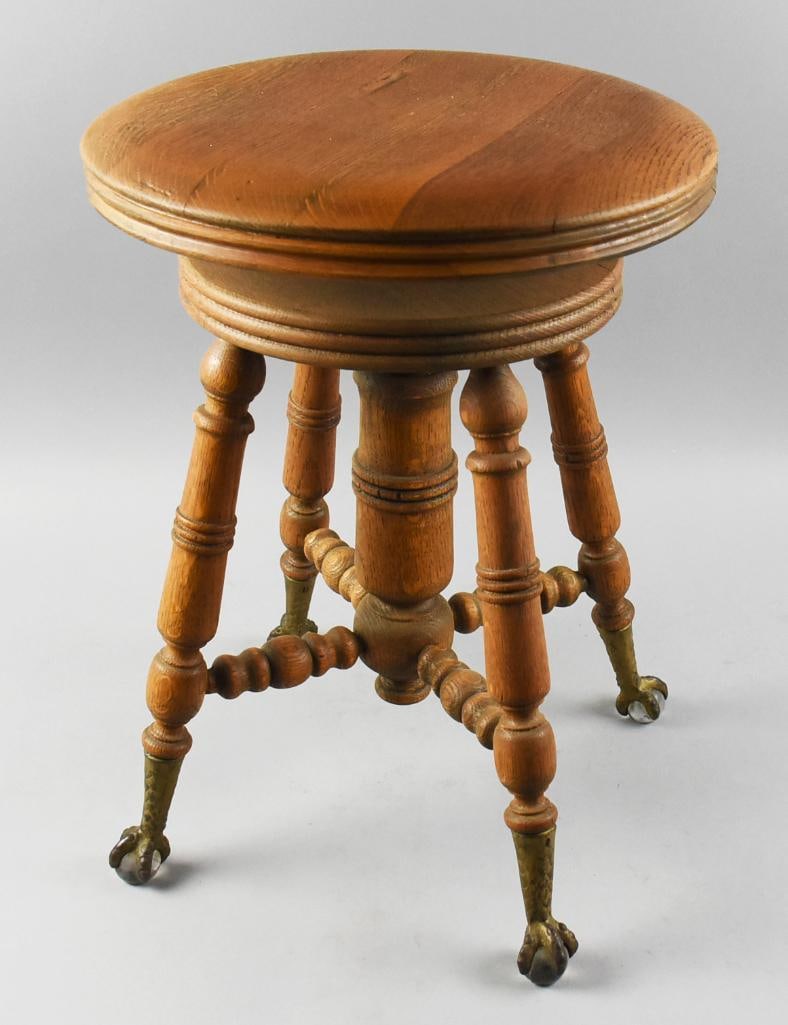 Victorian Piano Stool, Glass Ball Claw Feet: This is a wonderful antique stool. From the Victorian era, it is a solid wood stool, appears oak. Turned legs and stretches with brass claw feet, talons holding clear glass balls. Measures approx. 19"