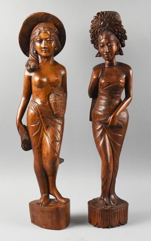 Vintage Large Balinese Hand Carved Women Figures: These beauties are from Bali. They are hand carved in what appears to be Suar?wood. One lady with draped skirt and one with wrapped dress. Each is marked BALI on bottom and stand approx. 25" tall.