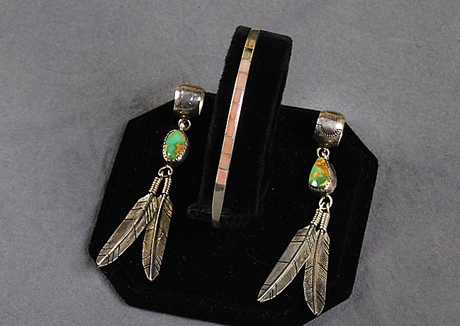 Native American feather cuff earrings and Bracelet: Pair of sterling and turquoise drop cuff feather earrings. Pinch the top closed to secure earrings. 2 1/4 inches long. Small pink stone and sterling bracelet signed "Rob". Missing one stone. 2.1/2 x 1