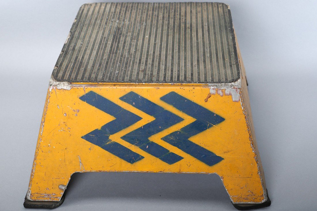 Ontario Northland Railroad Step Stool: Vintage railroad stool painted yellow with blue zig zag and rubber top, wooden feet. From the Ontario Northland Railroad. Shows wear from use. Measures 11 x 19 1/2 x 19 1/2.