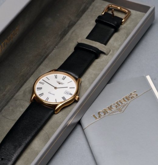 c1990 Longines Gentlemen's Wristwatch w/ Date: Great gentlemen's Longines slim wristwatch with black leather band. White dial with roman numerals and date window in 3 O'Clock position. Gold plate case. Presented in it's original box, with all the