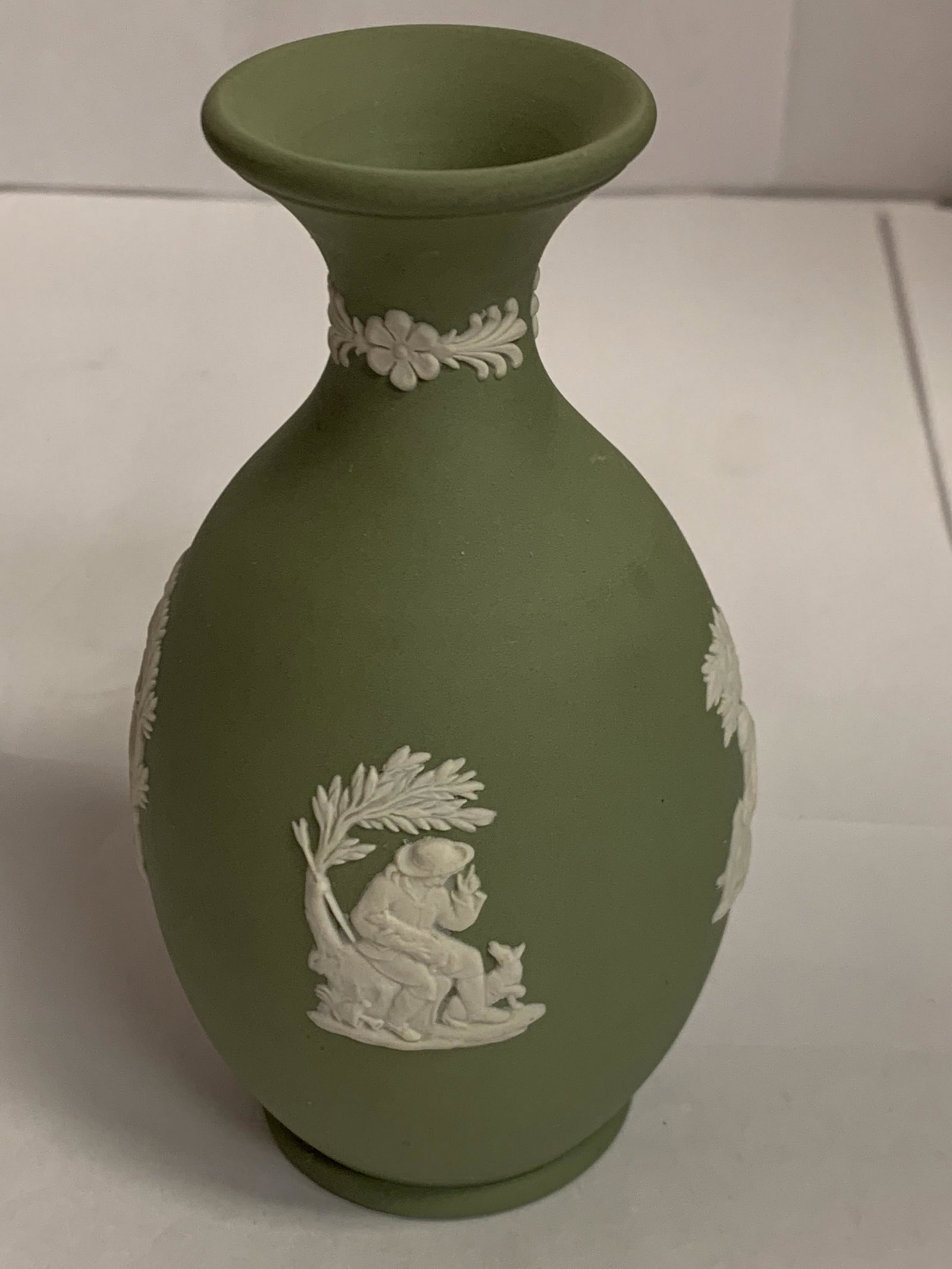 Nice Wedgwood Jasperware Small Green Vase 4 3/4" Tall Xlnt Cond: This is a great Wedgwood green small vase with 4 jasperware scenes. It depicts 2 musical cherubs, Poor Maria with dog, & a man with dogs. It is in wonderful condition with no flaws seen. It appears un