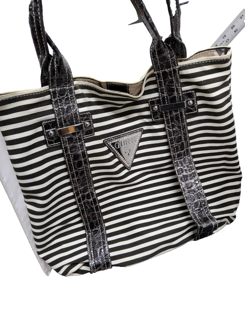 Guess Large Hobo Bag American Candy Black Striped Canvas & Leather Handbag: The Guess Large Hobo Bag American Dream Black Striped Canvas & Leather Handbag is a stylish and spacious handbag designed for casual occasions. Made with a combination of black canvas and leather,