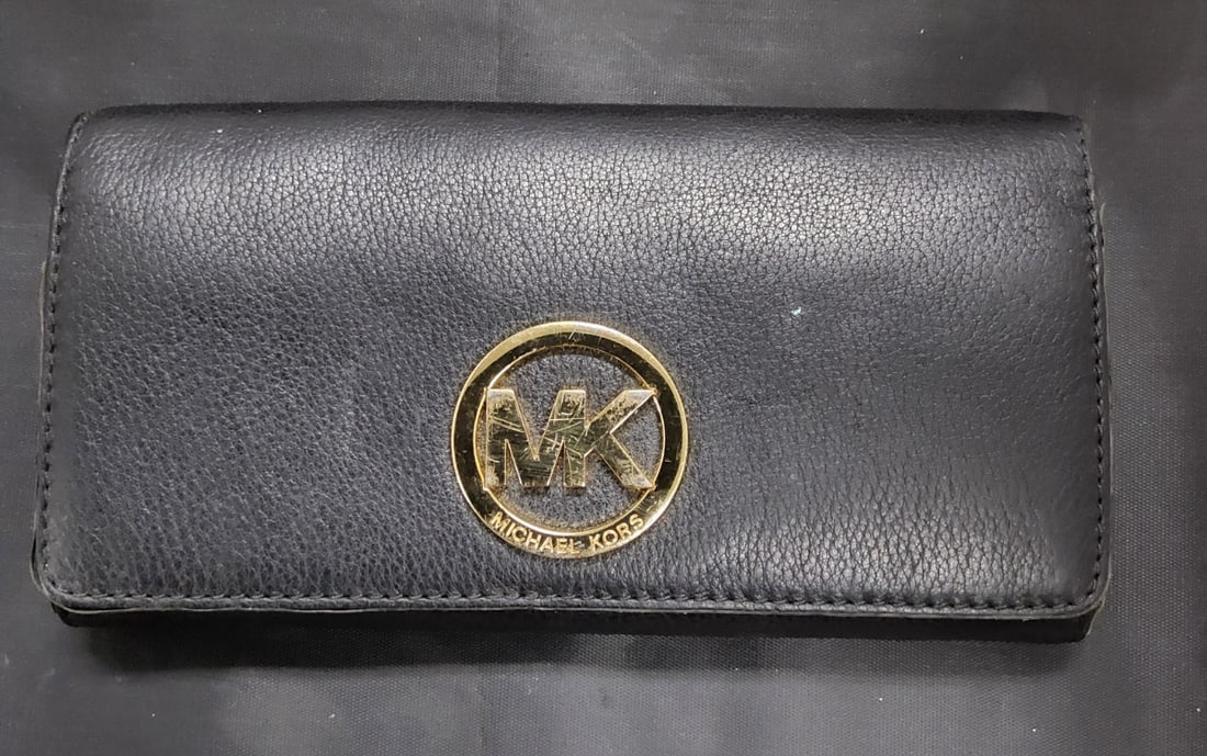 Michael Kors Fulton Carryall Leather Wallet: The Michael Kors Fulton Carryall Leather Wallet is a stylish and versatile accessory for women. Made from black leather with a pebbles pattern, this wallet features a solid design with a satin finish.