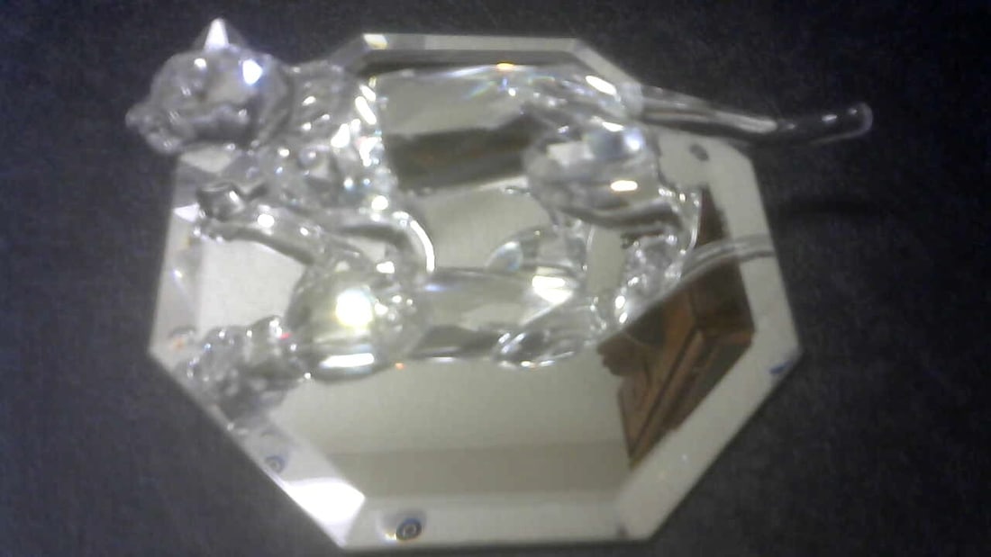 Swarovski Crystal Figurine, Leopard (217093) 5.5 MIB Collectible: This Swarovski crystal figurine is a must-have for any collector. The stunning leopard design, created by Michael Stamey in 1994, features faceted crystals that sparkle in the light. The figurine stan