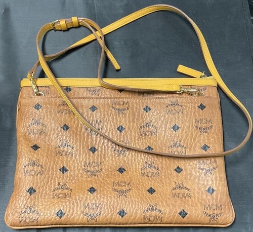MCM Visetos Liz Reversible Shopper Tote: The MCM Visetos Liz Reversible Shopper Tote is a stylish and versatile handbag perfect for women on the go. Made of leather with a monogram pattern, this small tote features a drawstring closure and a