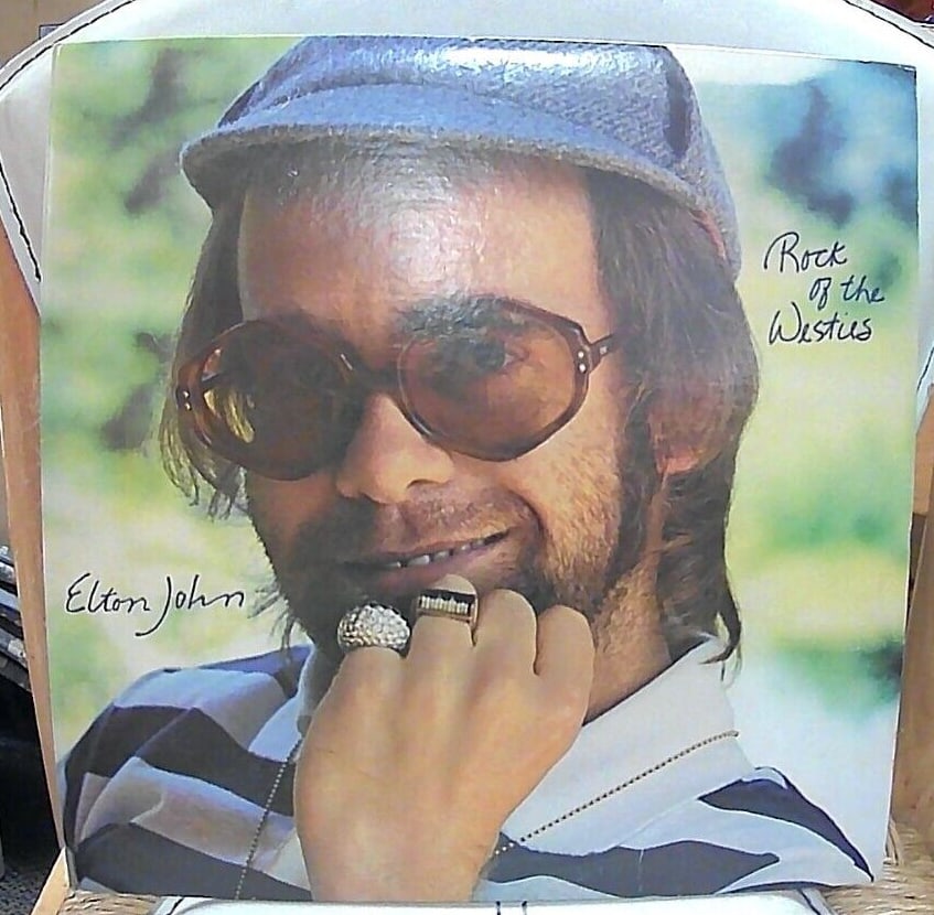 Elton John - Rock Of The Westies-LP- MCA-2163 1st 1975 USA: This vinyl record features Elton John's album "Rock of the Westies" with a 33 RPM speed and a 12-inch size. The cardboard sleeve and original cover add to the overall value of the first pressing editi