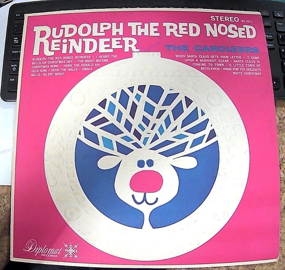 The Caroleers - Rudolph the Red Nosed Reindeer LP Diplomat SX 1011 1960's Press: Get into the holiday spirit with The Caroleers' Rudolph the Red Nosed Reindeer LP! This 33 RPM record features classic Christmas tunes that are sure to brighten up any holiday party. Released in the 1