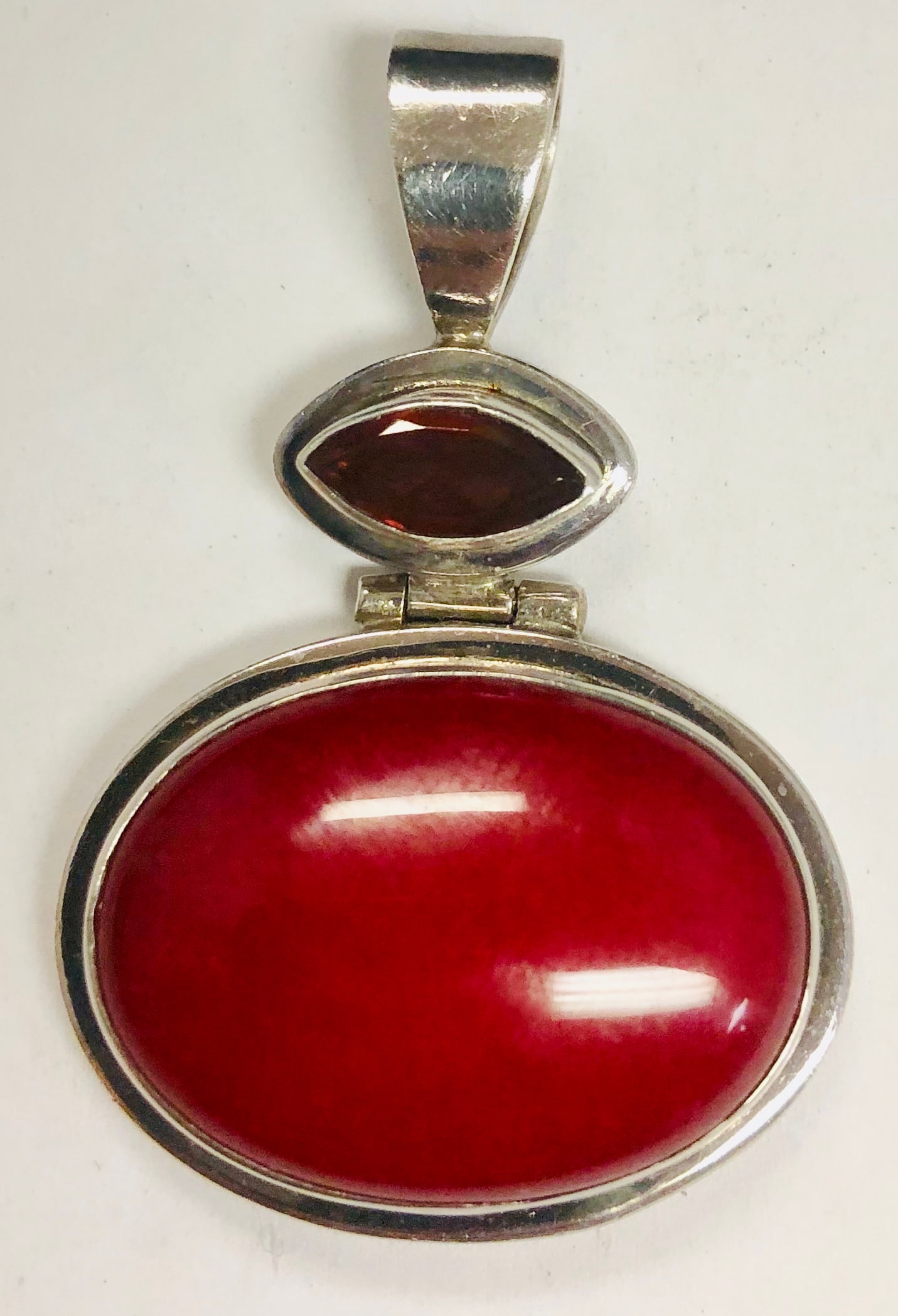 925 Sterling Silver Ladies Garnet & Red Agate pendant: 925 Sterling silver ladies garnet & red agate pendant. Center stone is a 24 x 17 oval red agate and has a 9 x 4 marque shaped garnet bezel set above the agate. Weight:: 9.1 Dwt