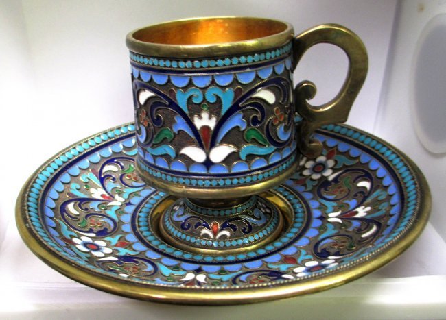 RUSSIAN SILVER ENAMELED TEA CUP & SAUCER: Russian Silver Enamel Tea Cup & Saucer with Gold Wash interior with multi floral design on Saucer and Cup. Tea Cup measures 2 1/2" Tall weights 86.8 Grams, Saucer measures 4 3/4" Diameter weights 131.