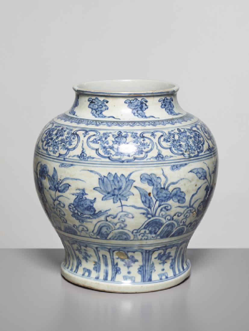 A BLUE AND WHITE 'LOTUS POND' BALUSTER JAR, MING: Robust and heavy pottery, the foot and inside unglazed. China, Ming Dynasty, 1368-1644 The rounded sides rising from a tapered foot to a waisted neck and rolled rim, painted with a wide central band o