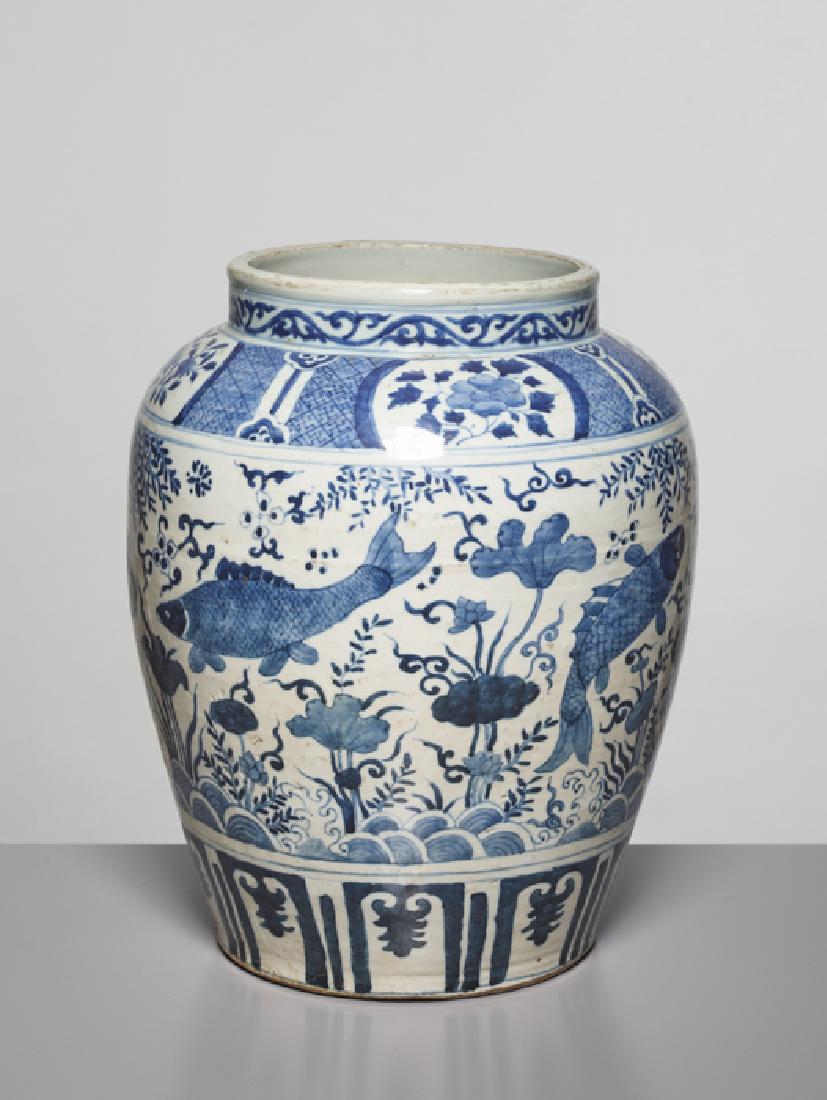 A BLUE AND WHITE 'FISH' JAR, WANLI: Porcelain with underglaze blue painting. China, Wanli Period (1573-1619), late Ming Dynasty Sturdily potted jar of large ovoid form. The wall with a revolving decoration of carps swimming in a lotus p