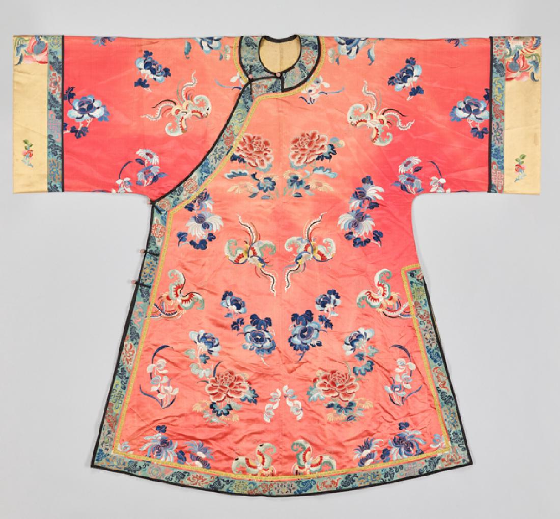 AN EMBROIDERED SILK MANCHU LADY'S ROBE, CHANGYI, QING: Silk with multi-colored silk, with woven application borders, inside with silk lining, five rose quartz buttons and fabric loops at the front. China, late Qing dynasty This dark pink Changyi robe show