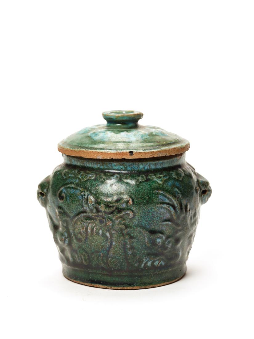 A GREEN GLAZED GINGER POT AND COVER, MING DYNASTY: A GREEN GLAZED GINGER POT AND COVER, MING DYNASTY Relief depiction of several animals under a pine tree, mock ring handles on the shoulders China, 16th – 17th century Dimensions: Height ca. 14 c