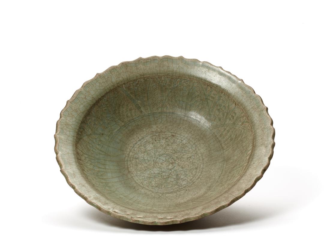 A LOBED CELADON CHARGER, MING DYNASTY: A LOBED CELADON CHARGER, MING DYNASTY The well with finely incised decor, the glaze with extensive crazing China, 15th – 16th century Dimensions: Diameter ca. 31 cm Condition: Good condition wit