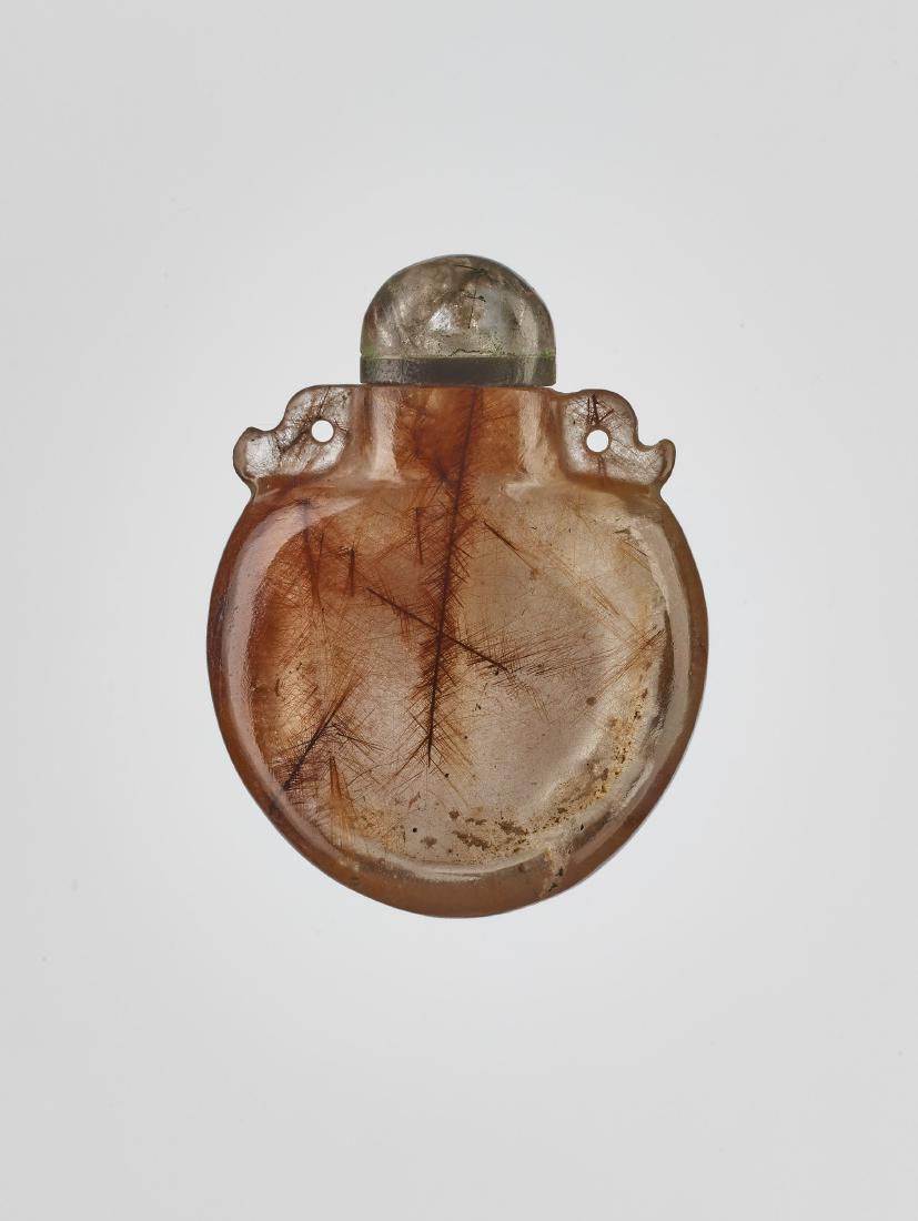 A TOURMALINE NEEDLE CRYSTAL SNUFF BOTTLE, 19th C.: A TOURMALINE NEEDLE CRYSTAL ‘PENDANT’ SNUFF BOTTLE, 19th CENTURY Transparent rock crystal with a very light brown tone and tourmaline needle inclusions, smooth surface polish China, 19th c