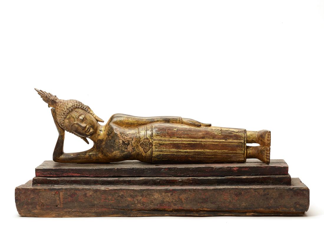 A BURMESE LACQUER GILT WOOD FIGURE OF A BUDDHA, 19 C.: A BURMESE LACQUER GILT WOOD FIGURE OF A RECLINING BUDDHA, LATE 19TH CENTURY Wood, gold lacquer Burma, late 19th century The Buddha reclining on an integrated base with parallel legs, one arm supportin