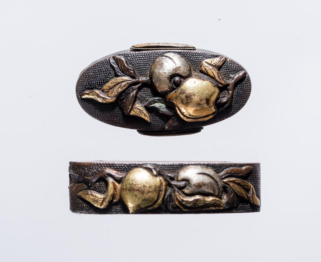 A FUCHI-KASHIRA: A FUCHI-KASHIRA Shibuichi, silver and gold foil Japan, Edo period (1615-1868) Bearing a shibuichi nanako ground carved in high relief and overlaid in gold and silver with fruit branches. Dimensions: H