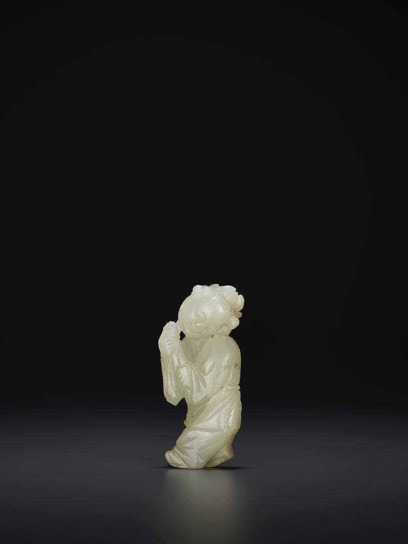 A JADE PENDANT, QING: A JADE PENDANT, QING China, 19th century. Neatly carved to depict a boy holding a peony. The stone of even celadon color with few small inclusions. Note the detail work to the flower, leaves and stem.