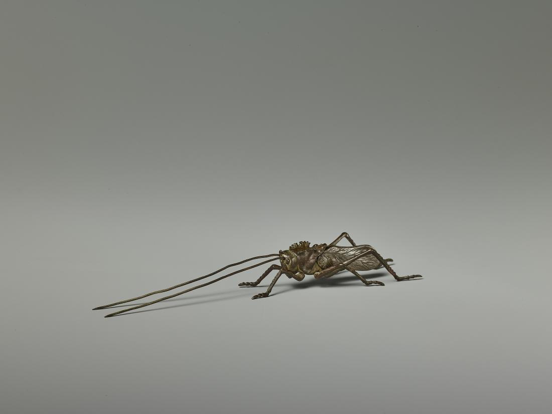 A RARE JIZAI OKIMONO OF A CRICKET, EDO PERIOD: A RARE JIZAI OKIMONO OF A CRICKET, EDO PERIOD Japan, 18th/19th century. The miniature bronze model of the insect with all six legs, both wings and both antennas movable! Fine patina and neatly incised