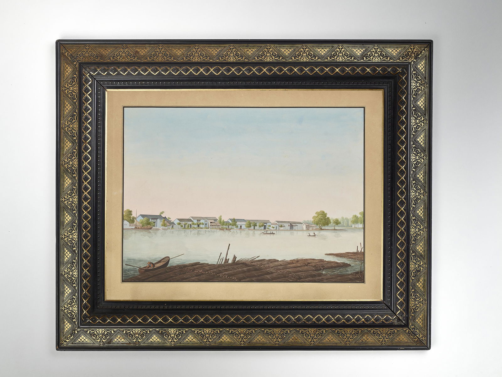 A CHINA TRADE WATERCOLOR, QING: A CHINA TRADE WATERCOLOR, QING China, 18th-19th century. Finely painted in watercolors and ink on paper to depict houses and boats on a river shore. Good European gold and stucco frame from the later