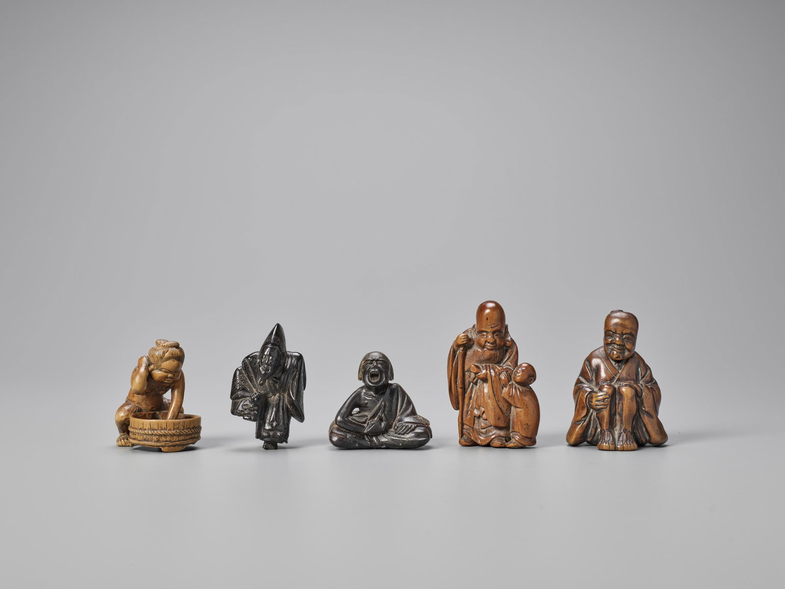 FIVE WOOD NETSUKE, ONE SIGNED: FIVE WOOD NETSUKE, ONE SIGNED The second signed Dai Hyuga Japan, 19th century to Meiji period (1868-1912) The first a depiction of Okame washing herself, the second an ebony Sanbaso dancer, signed DAI