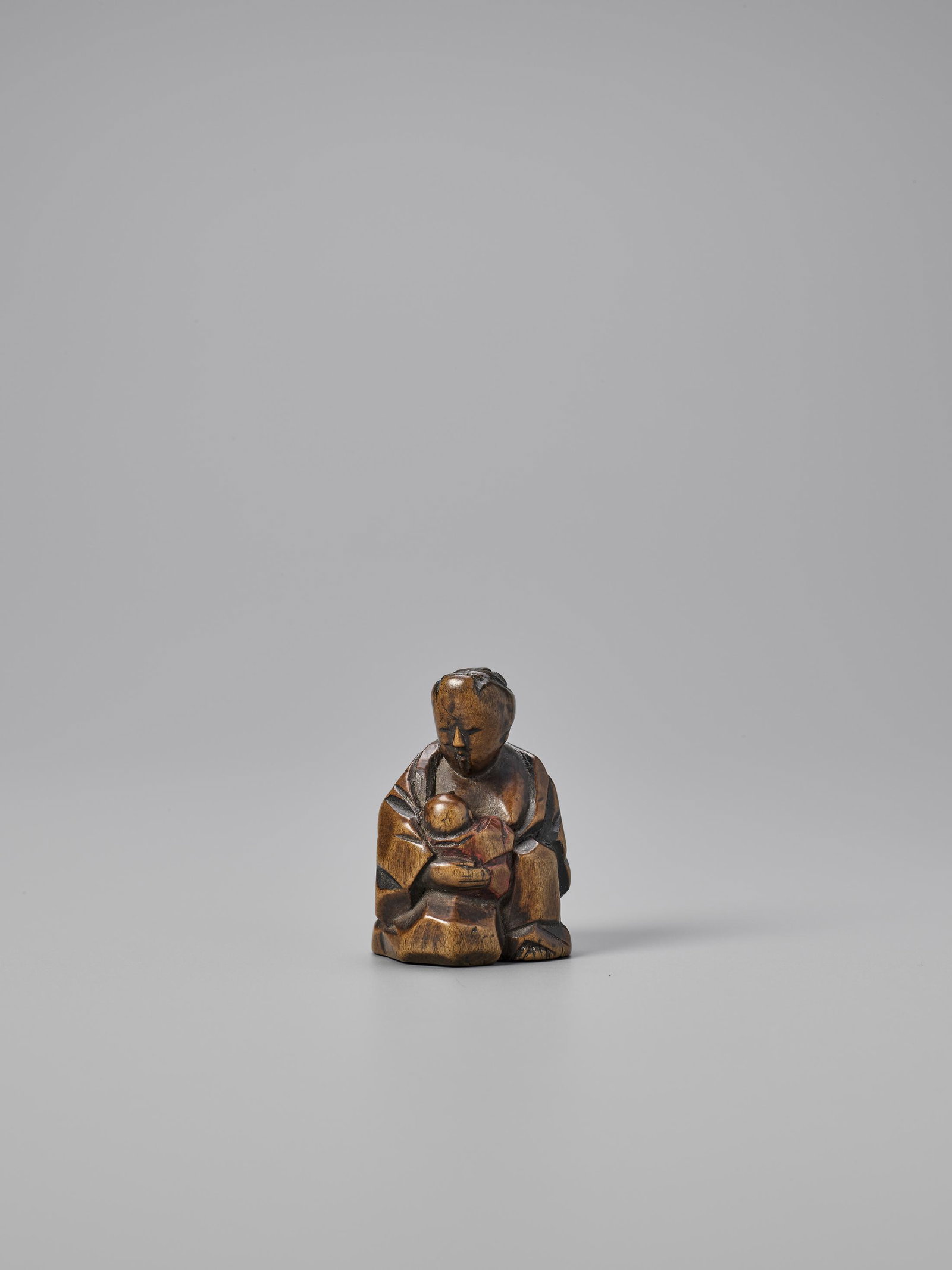 A RARE HIDA SCHOOL ITTOBORI SHUNGA NETSUKE: A RARE HIDA SCHOOL ITTOBORI SHUNGA NETSUKE Unsigned Japan, 19th century, Edo period (1615-1868) Depicting a mother nursing a young child, carved from wood and using the ittobori technique (using one k