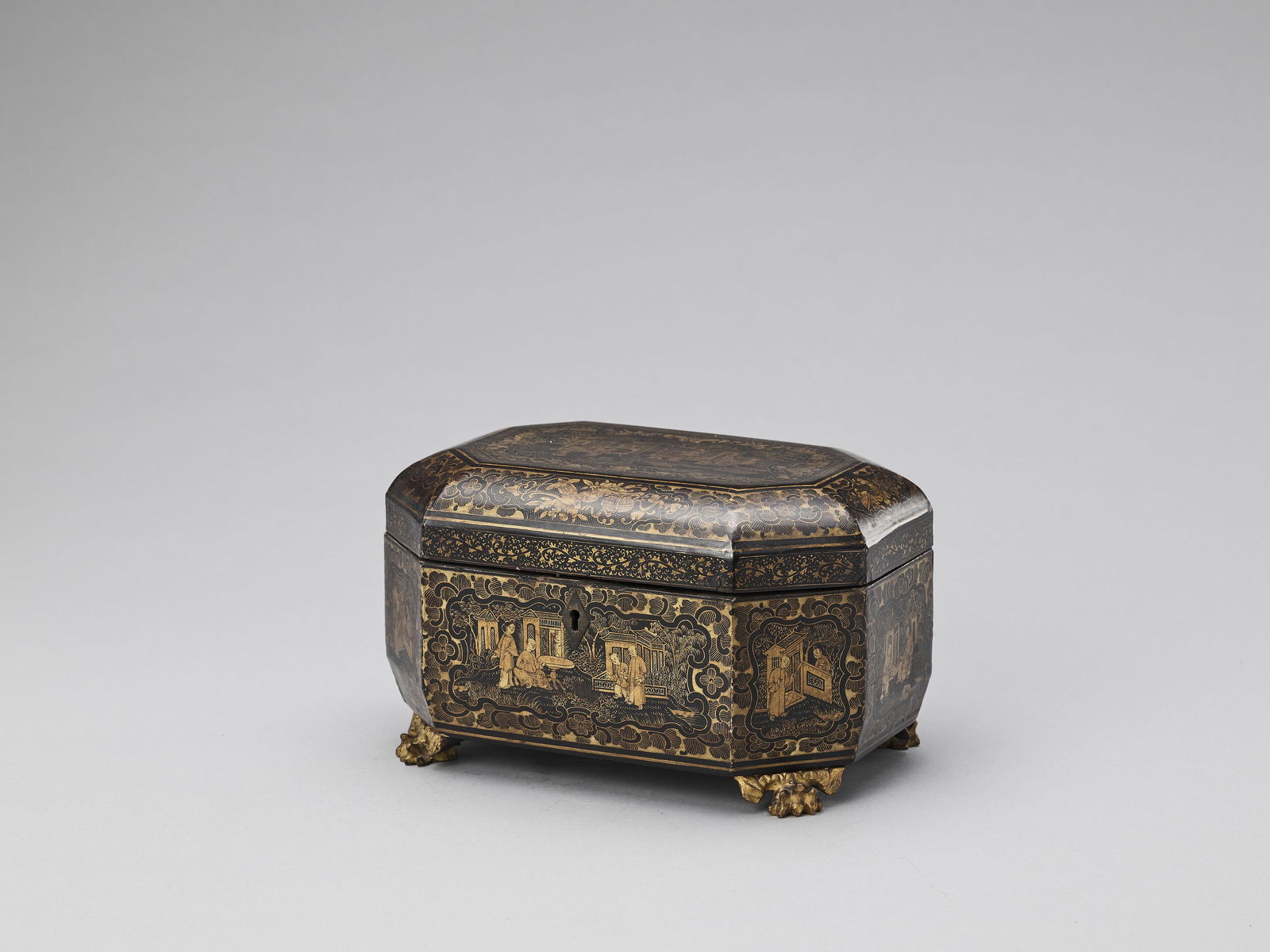 A CANTON LACQUER HEXAGONAL TEA CADDY WITH ORIGINAL TEA: A CANTON LACQUER HEXAGONAL TEA CADDY WITH ORIGINAL TEA CONTAINERS, QING China, 1644-1912. The octagonal box on four carved wood claw-shaped feet and with a hinged cover, painted all over with old blac