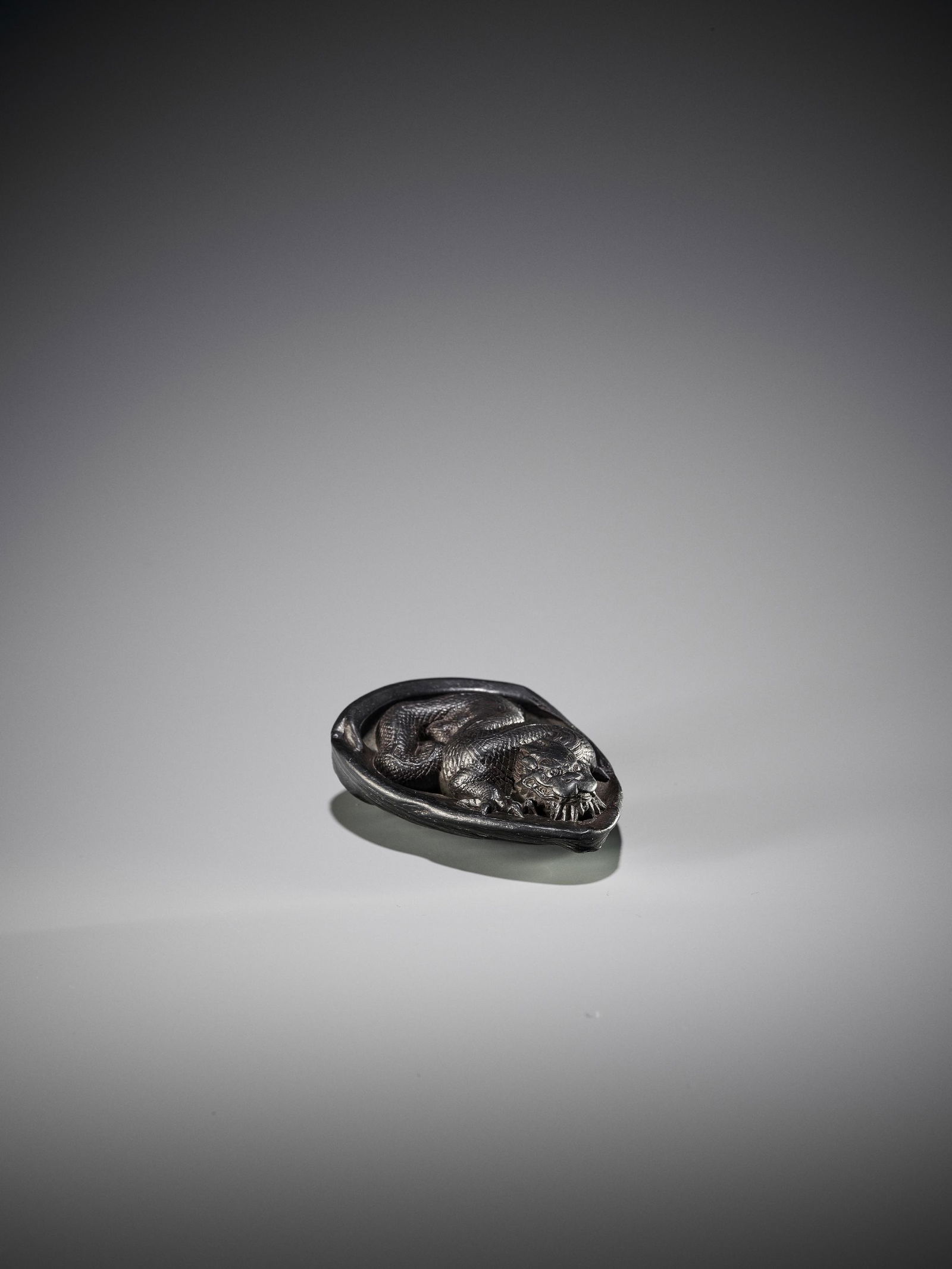 SUPERB EBONY WOOD NETSUKE OF A DRAGON IN AWABI: A VERY RARE AND SUPERB EBONY WOOD NETSUKE OF A DRAGON IN AWABI SHELL Unsigned Japan, Iwami province, late 18th century, Edo period (1615-1868) Published: Earle, Joe (2000) The Robert S. Huthart Collec