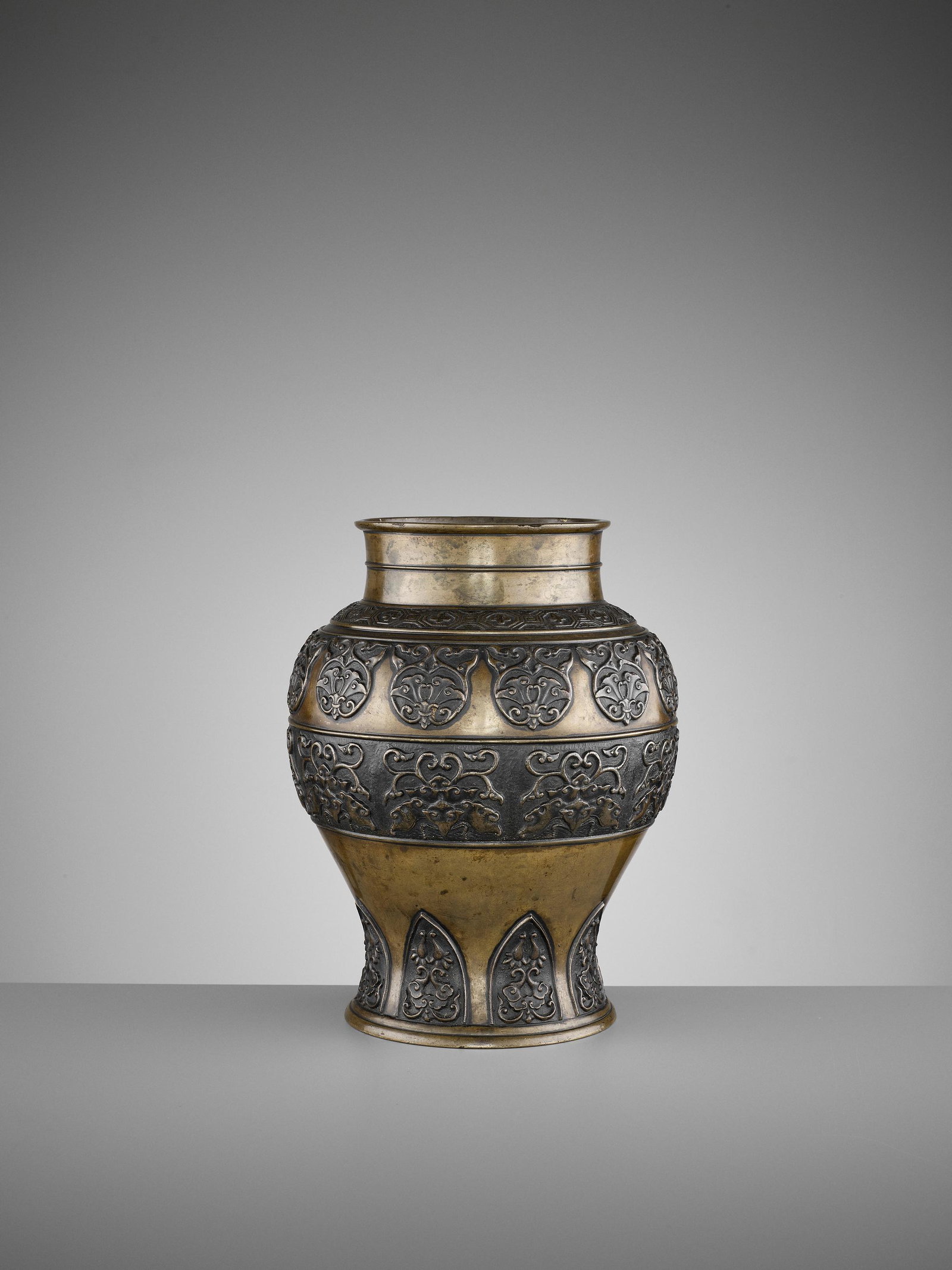 AN ARCHAISTIC BRONZE BALUSTER VASE, 17TH CENTURY: AN ARCHAISTIC BRONZE BALUSTER VASE, 17TH CENTURY China, late Ming to early Qing dynasty. Heavily cast, the shoulder incised with a band of flowers in octagonal reserves surrounded by geometric pattern