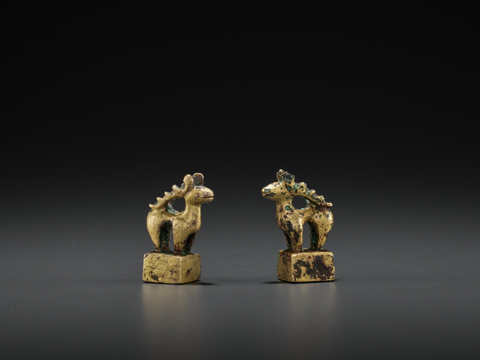 A PAIR OF GILT BRONZE 'STAG' SEALS, EASTERN HAN: A PAIR OF GILT BRONZE 'STAG' SEALS, EASTERN HAN China, 25-220 AD. The bases of square shape cast in intaglio with two-character seals, each surmounted by a stag with jagged antlers. (2) Provenance: Pa