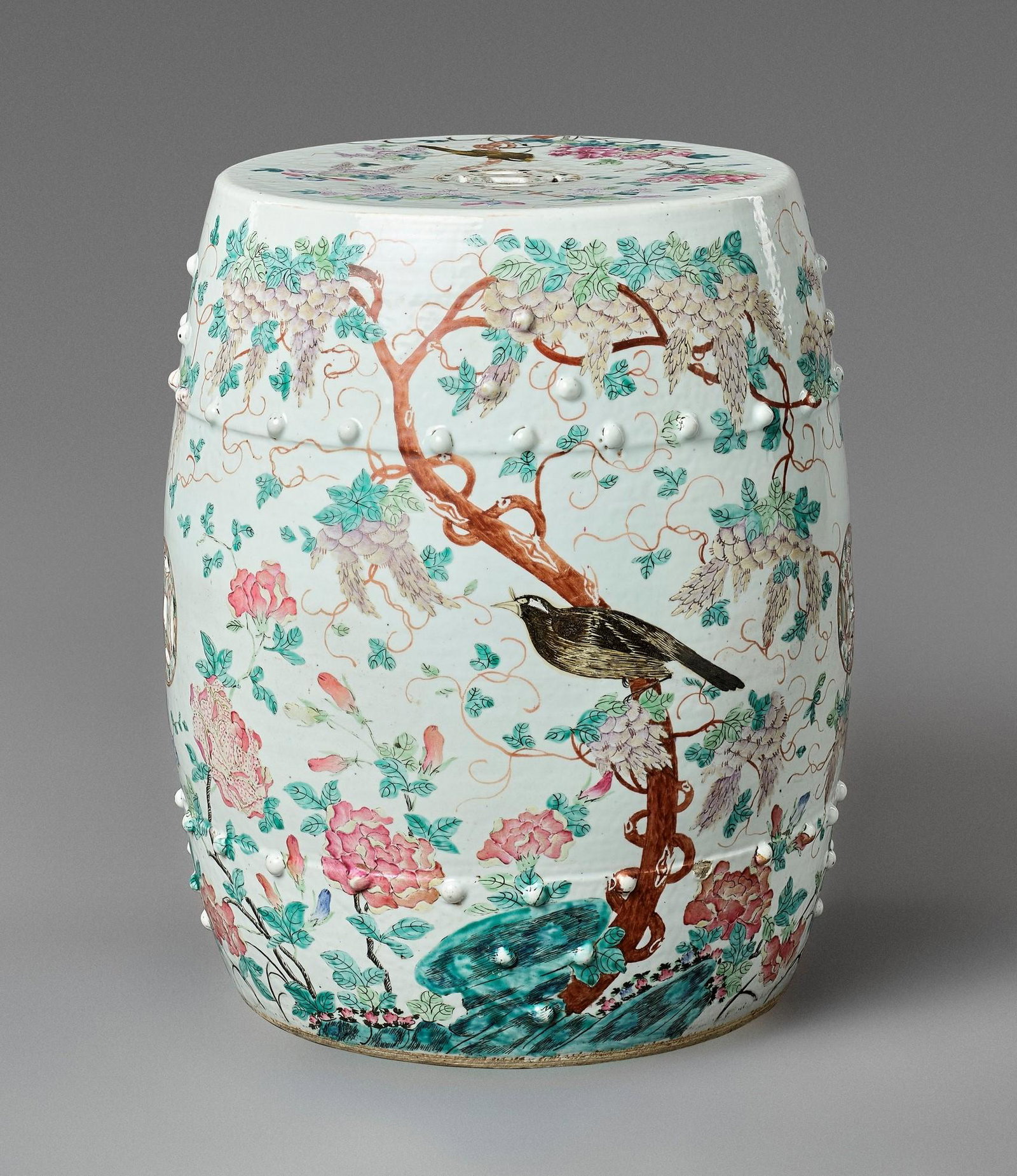 A FAMILLE ROSE 'MAGPIES' GARDEN STOOL, QING: A FAMILLE ROSE 'MAGPIES' GARDEN STOOL, QING DYNASTY China, 19th century. Of barrel form with a slightly convex top, centered by a pierced cash symbol, brightly enameled around the exterior with magpie