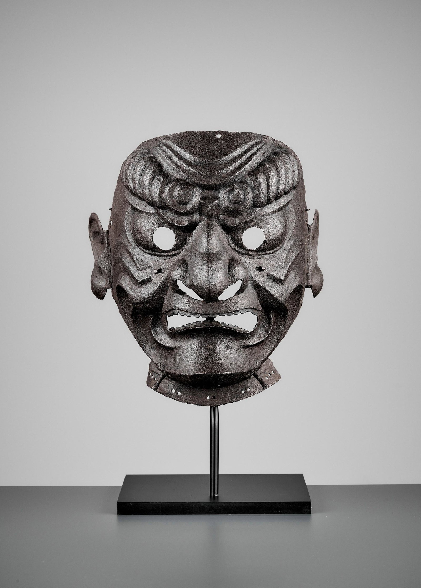 AN EXTREMELY RARE MYOCHIN-SCHOOL IRON SOMEN: AN EXTREMELY RARE MYOCHIN-SCHOOL IRON SOMEN Japan, mid-Edo period (1615-1868) Forged in sections with a removable nose plate and expressively designed with deeply embossed furrowed eyebrows and deep w
