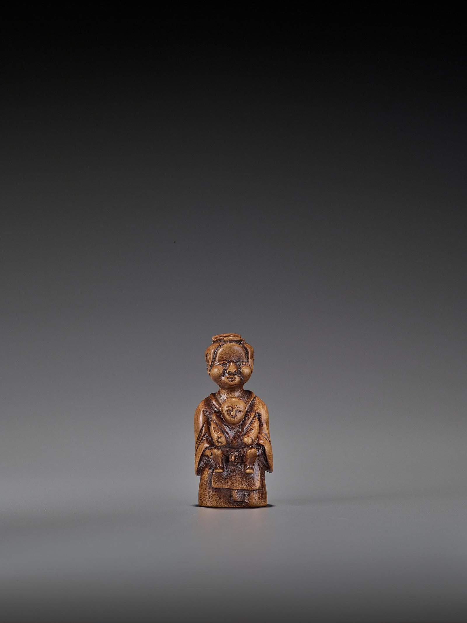 A WOOD 'DOUBLE SHUNGA' NETSUKE OF A MOTHER AND CHILD: A RARE WOOD 'DOUBLE SHUNGA' NETSUKE OF A MOTHER AND CHILD Unsigned Japan, 18th century, Edo period (1615-1868) A highly suggestive and early shunga netsuke carved as a mother, with chubby cheeks and a