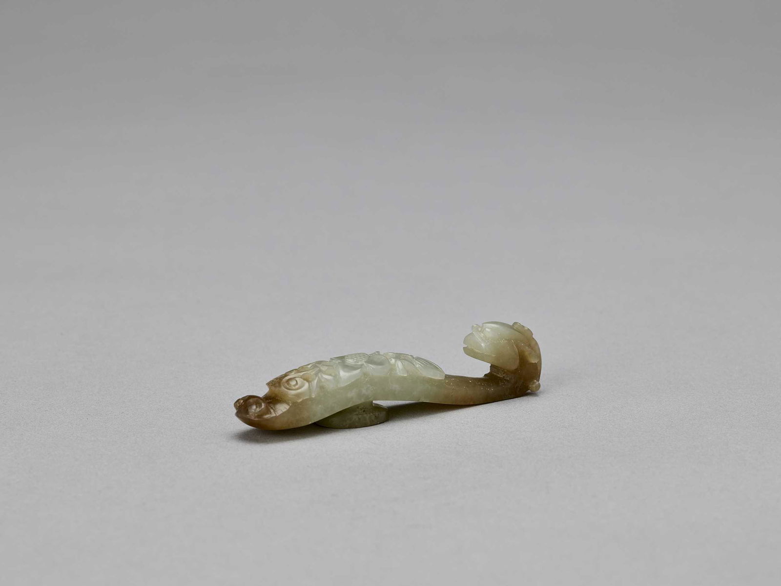 A DEEP CELADON AND RUSSET JADE 'DRAGON' BELT HOOK, QING (1 of 5)