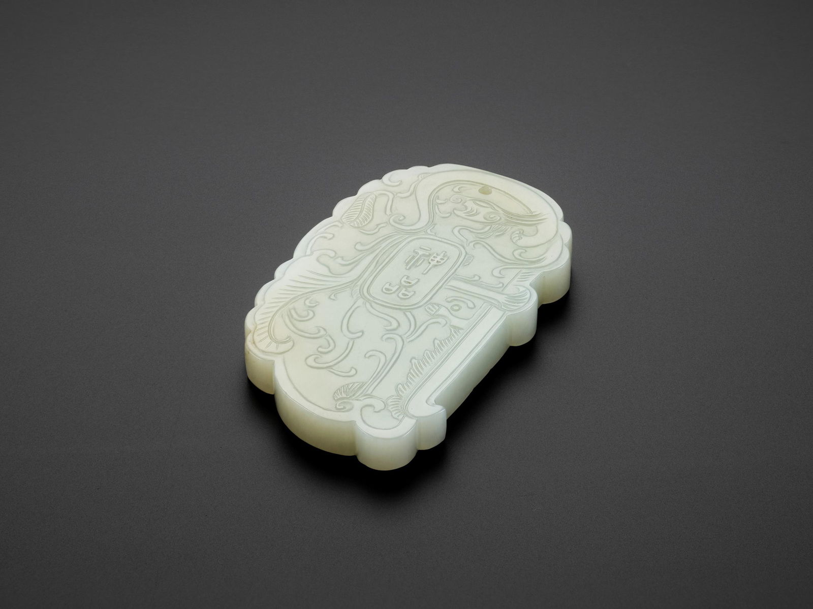AN INSCRIBED WHITE JADE PLAQUE, LATE QING TO REPUBLIC: AN INSCRIBED WHITE JADE PLAQUE, LATE QING TO REPUBLIC China, 1850-1950. Of flattened rectangular form with rounded corners, neatly carved and incised to each side in shallow relief with an oval cartou
