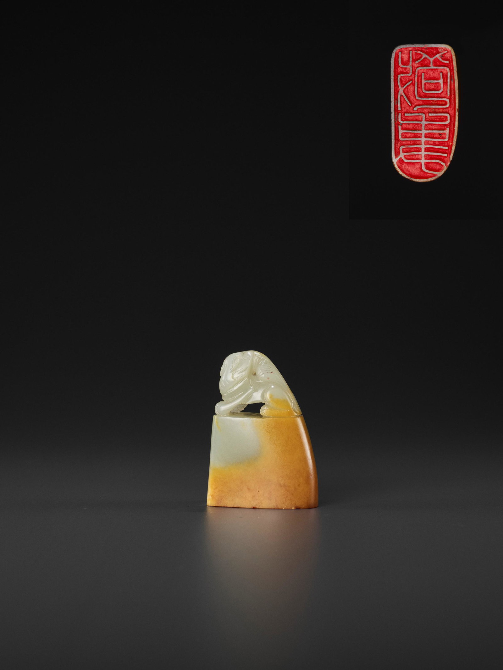 A JADE 'BUDDHIST LION' SEAL, MID-QING TO REPUBLIC: A PALE CELADON AND AMBER JADE 'BUDDHIST LION' SEAL, MID-QING TO REPUBLIC China, late 18th to early 20th century. Of rounded-rectangular form, surmounted by a Buddhist lion seated foursquare with its b