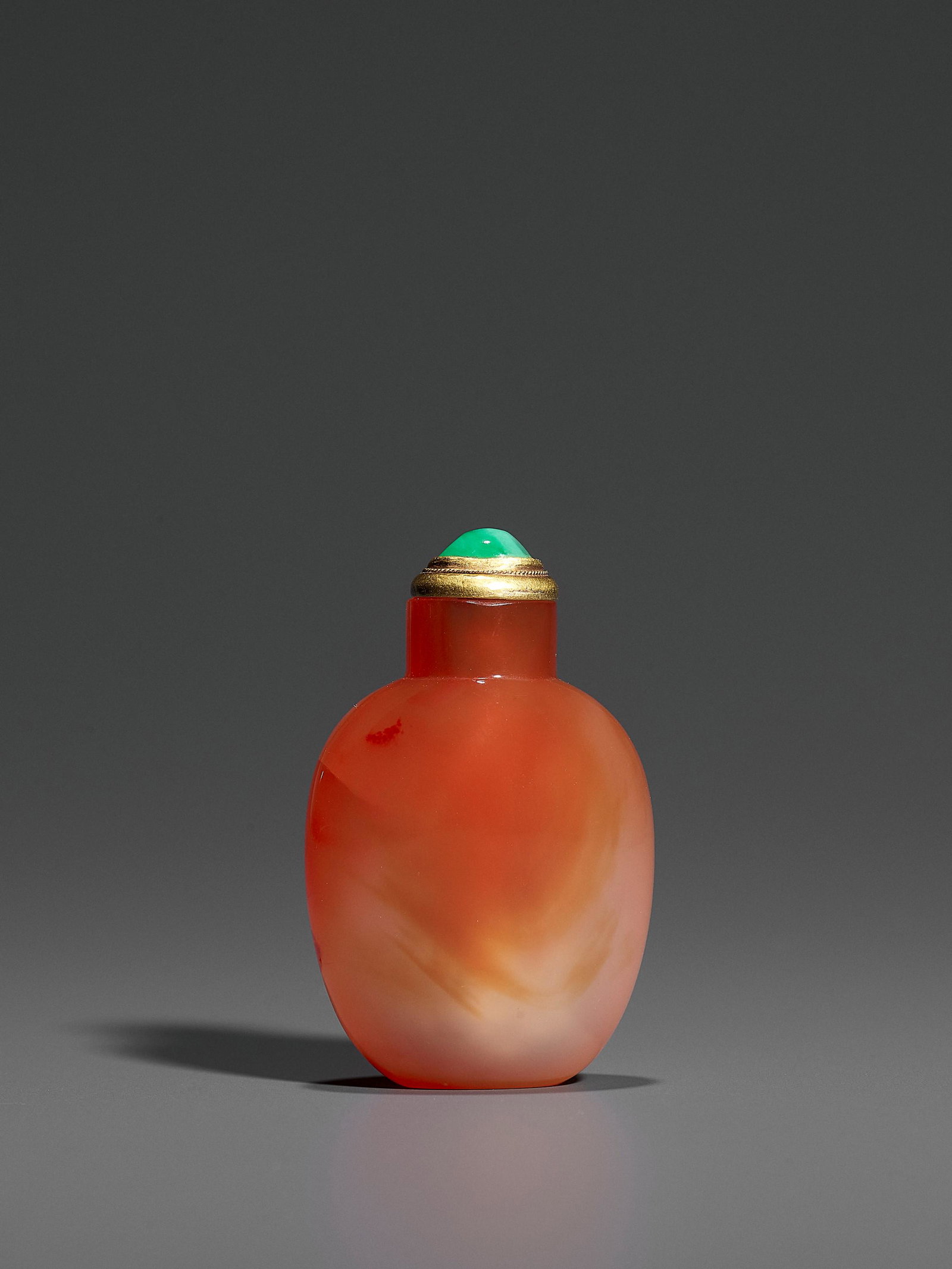 A CARNELIAN SNUFF BOTTLE, QING DYNASTY: A CARNELIAN SNUFF BOTTLE, QING DYNASTY China, 1750-1880. Of compressed ovoid form with a convex top and a flat foot, the semi-translucent mottled and finely polished stone shading from creamy-beige to