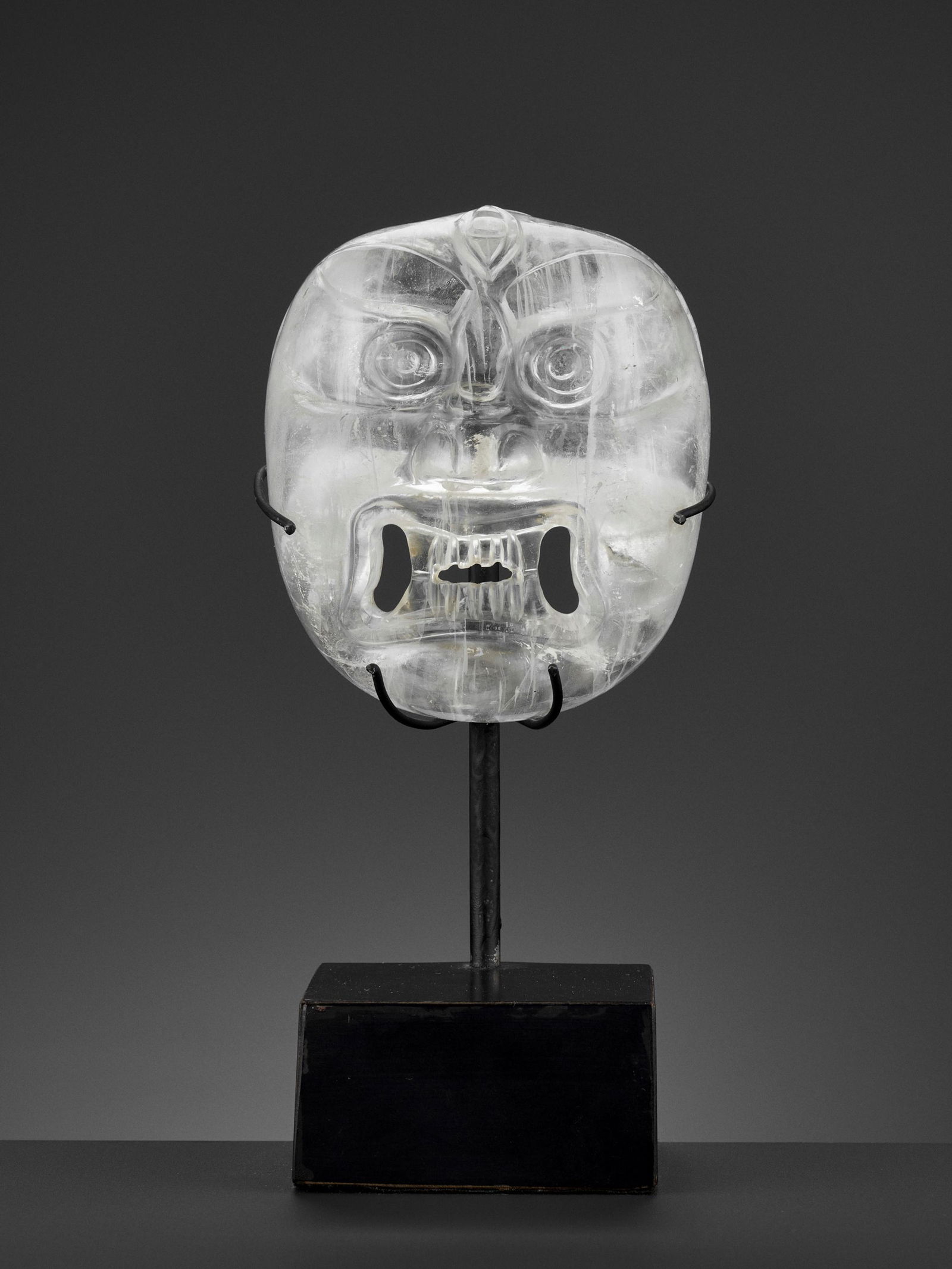 A CARVED ROCK CRYSTAL MASK OF BHAIRAVA, 18TH-19TH: A CARVED OPENWORK ROCK CRYSTAL MASK OF BHAIRAVA, 18TH-19TH CENTURY Nepal. The wrathful deity's fierce face with round bulging eyes, thick furrowed brows below the third eye, a broad nose with prominen